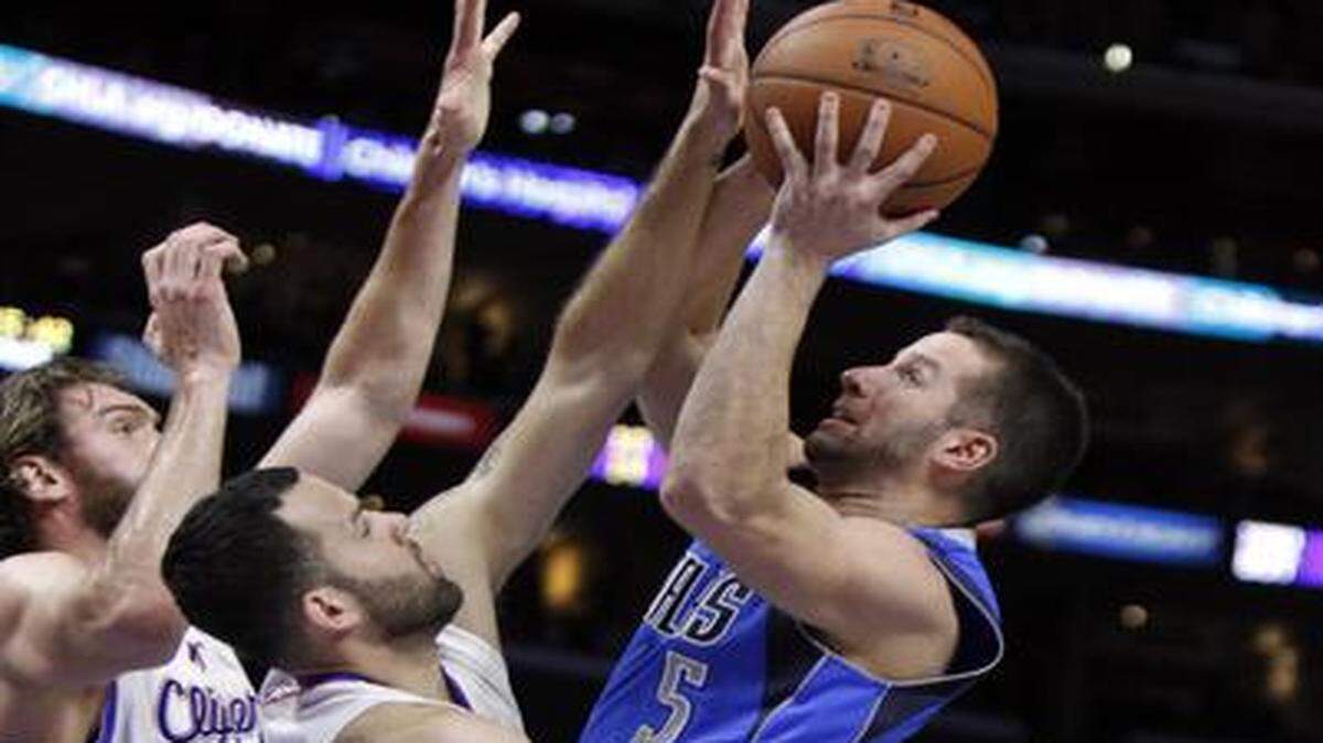 
Mavericks guard J.J. Barea, right, finds little room to get off a shot against the tight defense of Clippers guard Jordan Farmar and forward Spencer Hawes, left.
