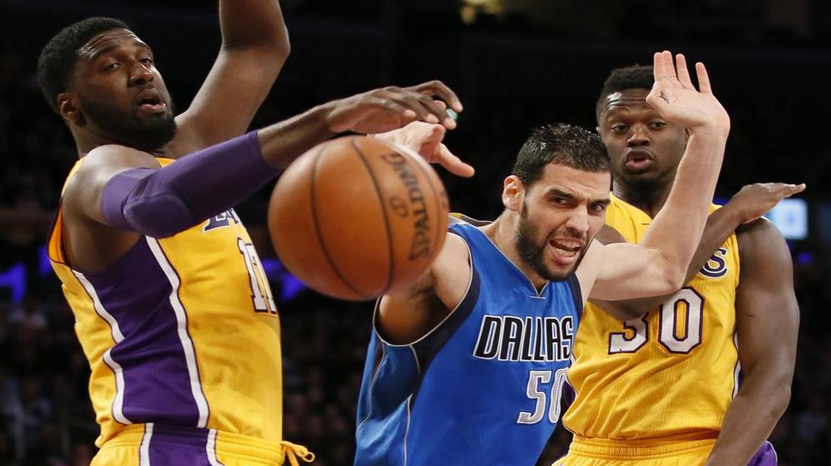 Mavericks center Salah Mejri loses the ball between Los Angeles Lakers defenders Roy Hibbert, left, and Julius Randle during Tuesday night’s game in Los Angeles.