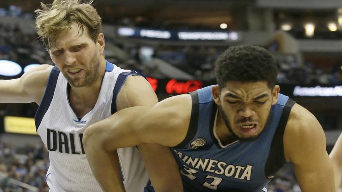Minnesota Timberwolves center Karl-Anthony Towns (32) and Dallas Mavericks forward Dirk Nowitzki (41) battle for control of the ball during the first half Sunday in Dallas.