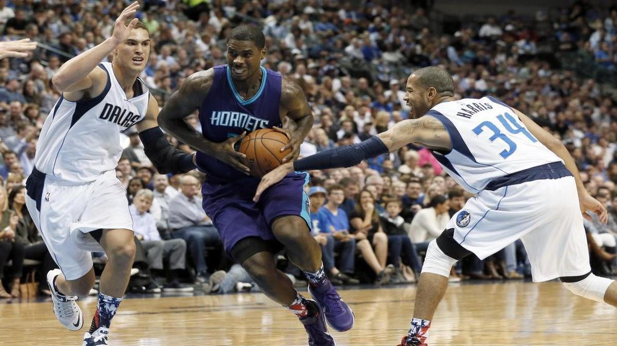 Mavericks’ Dwight Powell, left, and Devin Harris defend a drive to the basket by Charlotte Hornets forward Marvin Williams during Thursday’s game in Dallas.