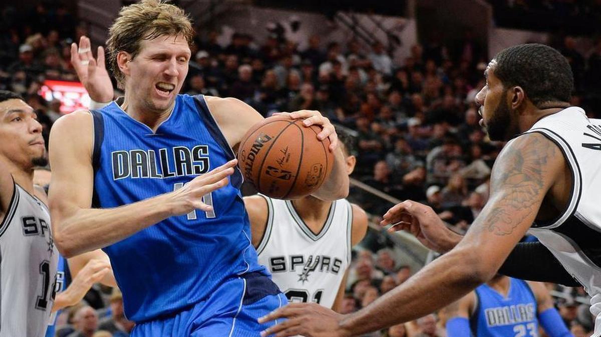 Dallas Mavericks forward Dirk Nowitzki, center, of Germany, drives between San Antonio Spurs guard Danny Green, left, and Spurs forward LaMarcus Aldridge during the first half.