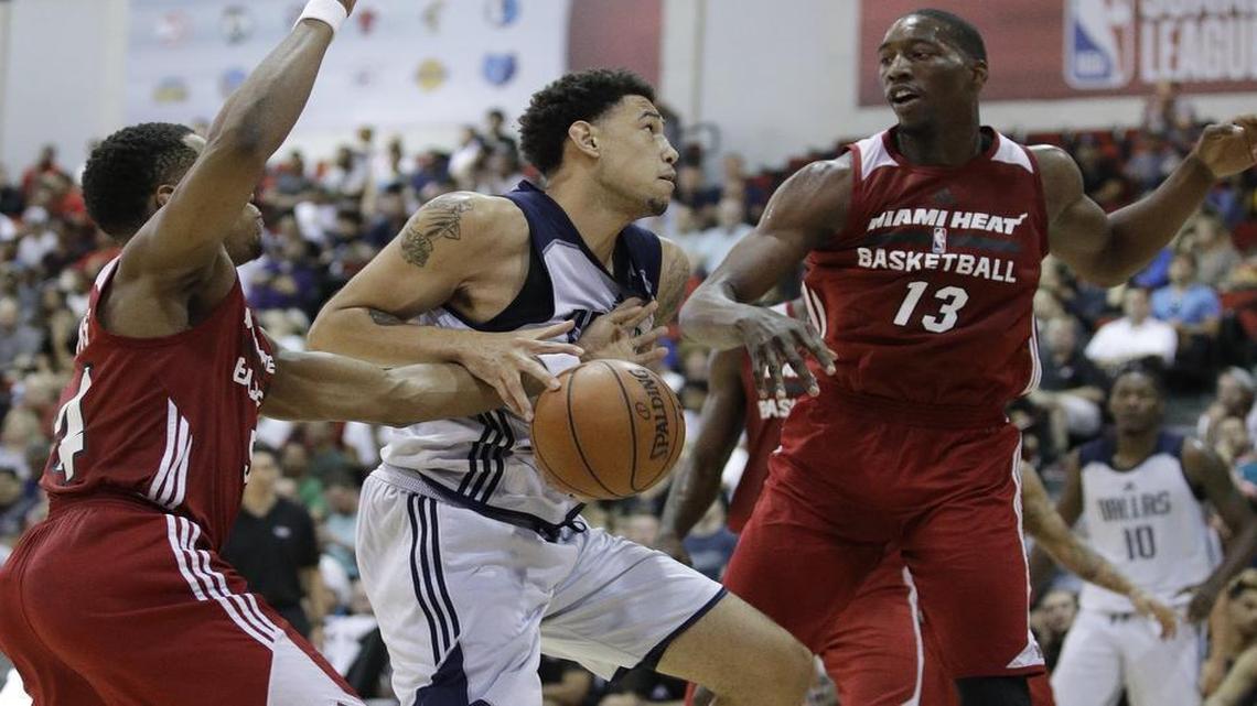 Mavericks center Brandon Ashley, middle, gets pestered by Miami’s Matt Williams, left, and Bam Adebayo.