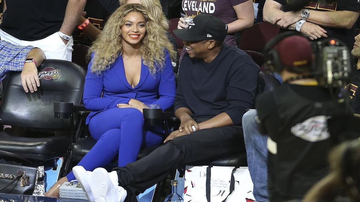 Beyoncé and husband Jay-Z enjoy a conversation during an NBA Finals game in 2016. Bloomberg has reported that Beyoncé is considering buying into an NBA team.