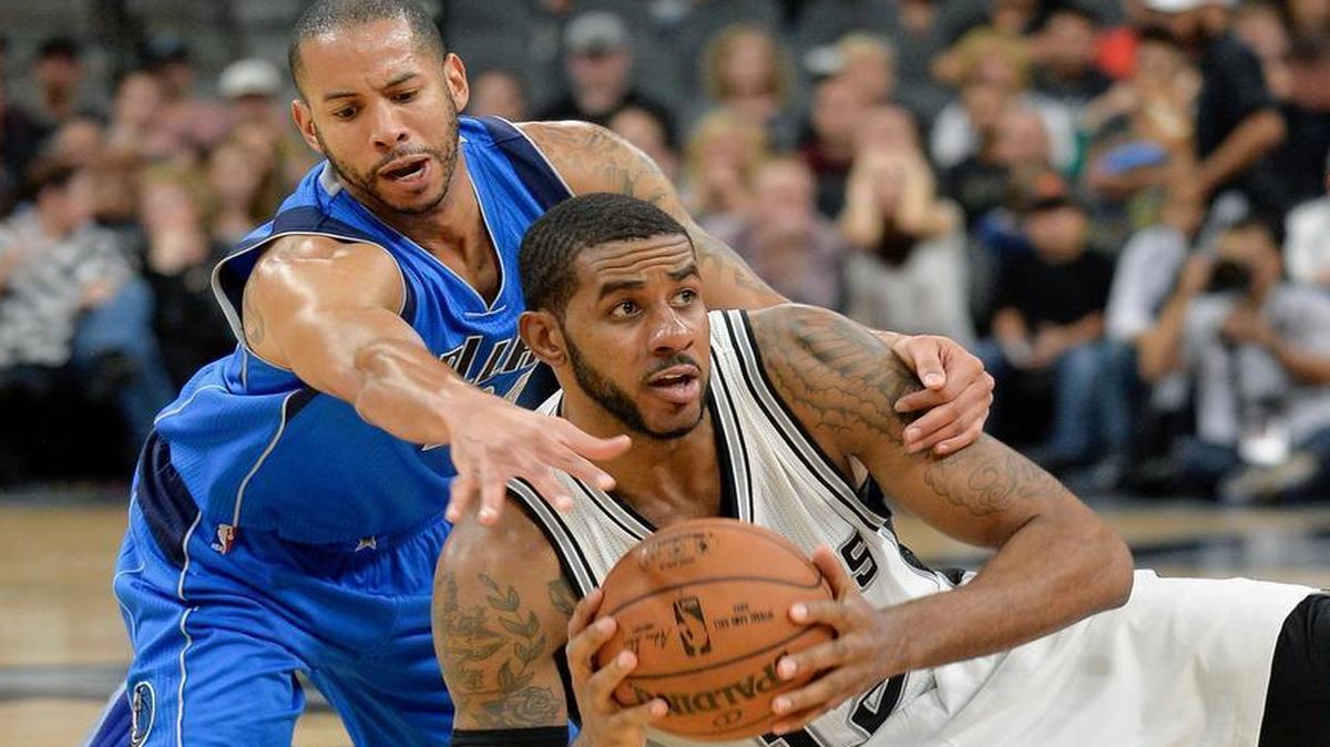 San Antonio Spurs forward LaMarcus Aldridge, right, tangles with Dallas Mavericks guard Devin Harris during the second half of an NBA basketball game, Wednesday, Nov. 25, 2015, in San Antonio. San Antonio won 88-83.