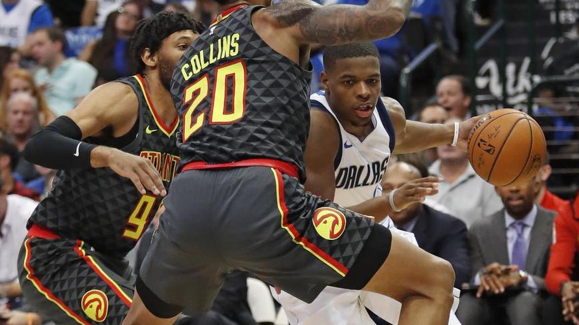 Mavericks guard Dennis Smith Jr. drives around Atlanta Hawks forward John Collins during the season opener and his NBA debut Wednesday night. The Mavs lost 117-11 at American Airlines Center.