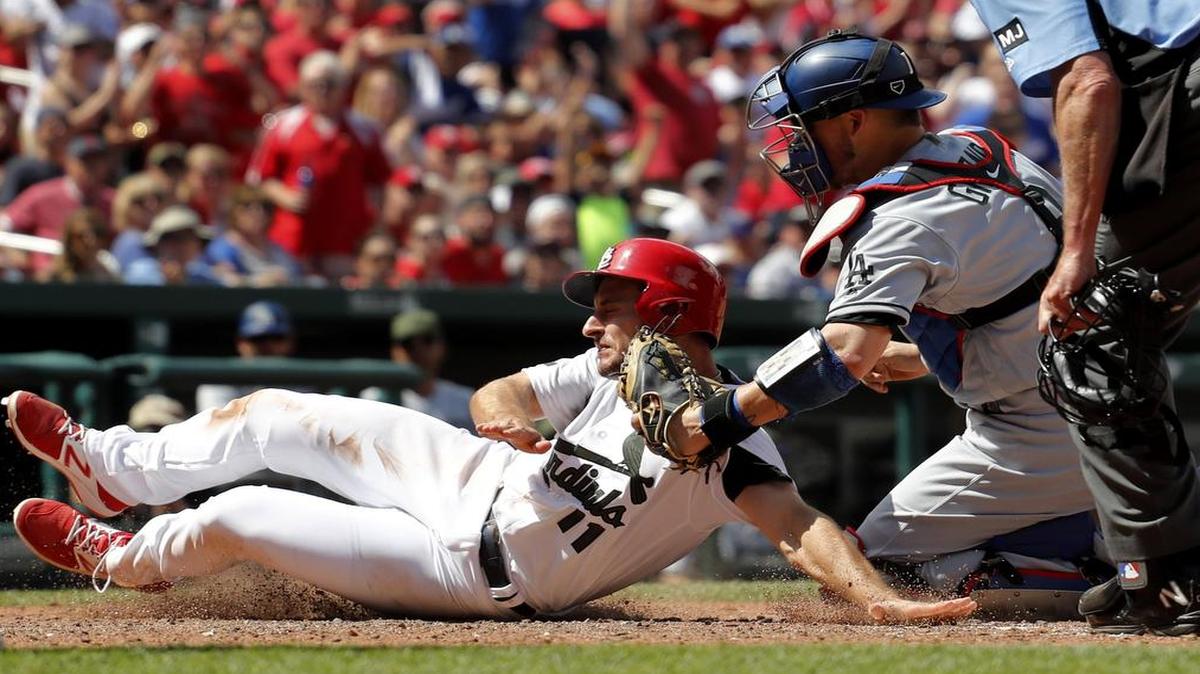 Los Angeles Dodgers catcher Yasmani Grandal tags out the St. Louis Cardinals’ Paul DeJong during the seventh inning Monday. The Dodgers won the Memorial Day showdown 5-1 in St. Louis. The teams resume their series Tuesday at 6 p.m. on ESPN.