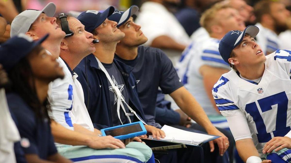 Dallas Cowboys quarterback Brandon Weeden (3), offensive coordinator Scott Linehan, Tony Romo, Matt Cassel (16), and Kellen Moore (17) look at the video board in the 2015 game against the Atlanta Falcons. The four quarterbacks represent a first-round draft bust, a free-agent gem, a seventh-round pick and a free-agent reserve.