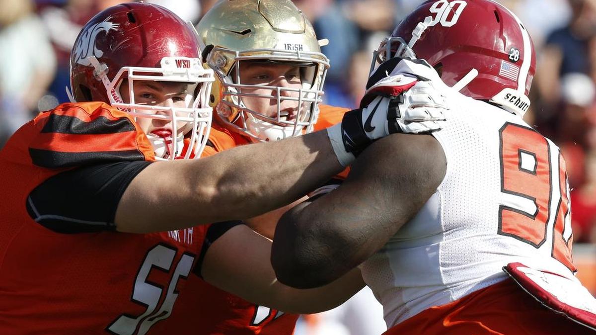 North squad offensive linemen Joe Dahl, left, of Washington State and Nick Martin of Notre Dame block South squad defensive end Jarran Reed during the first half of the the Senior Bowl.
