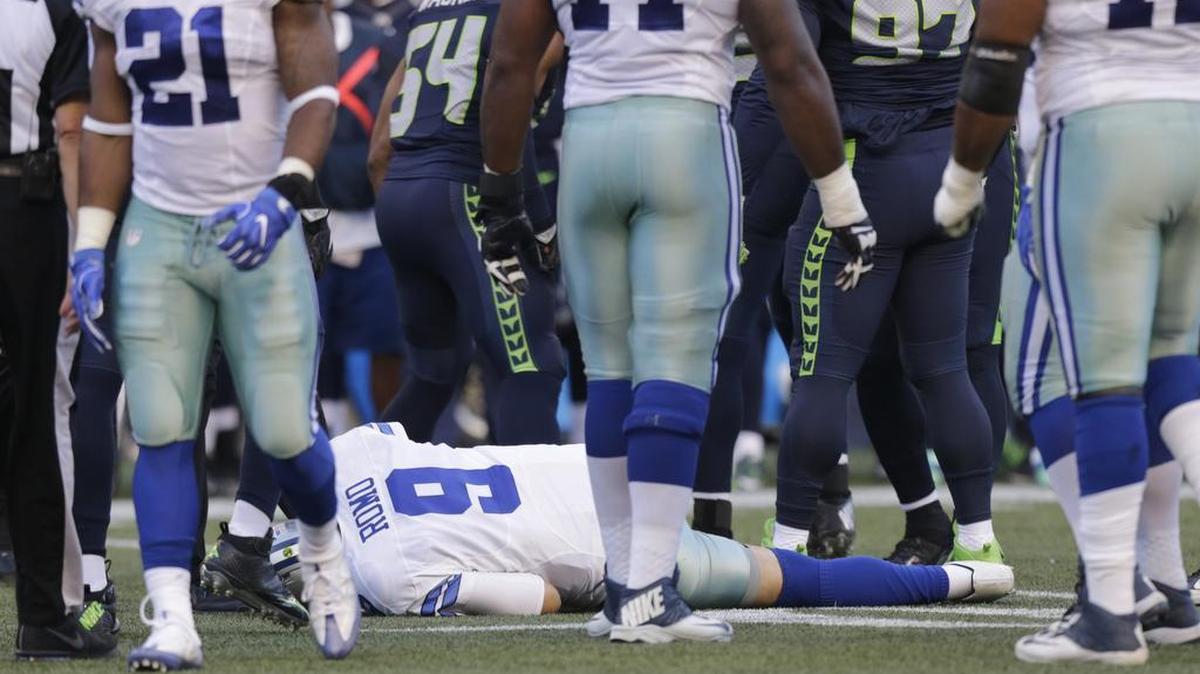 Dallas Cowboys quarterback Tony Romo lies on the turf after going down on a play against the Seattle Seahawks in the first half of a preseason NFL football game, Thursday, Aug. 25, 2016, in Seattle.