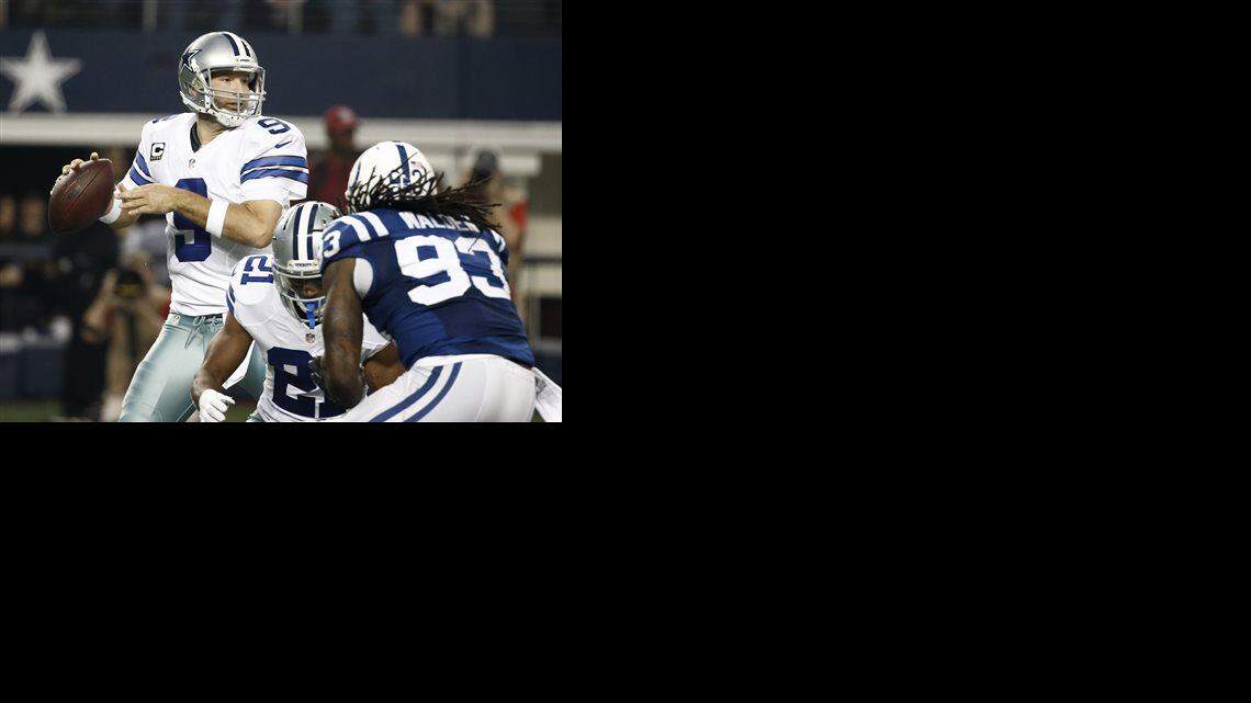 Dallas Cowboys quarterback Tony Romo (9) prepares to pass as running back Joseph Randle (21) picks up the pressure from Indianapolis Colts outside linebacker Erik Walden (93) during the first half of an NFL football game, Sunday, Dec. 21, 2014, in Arlington, Texas.