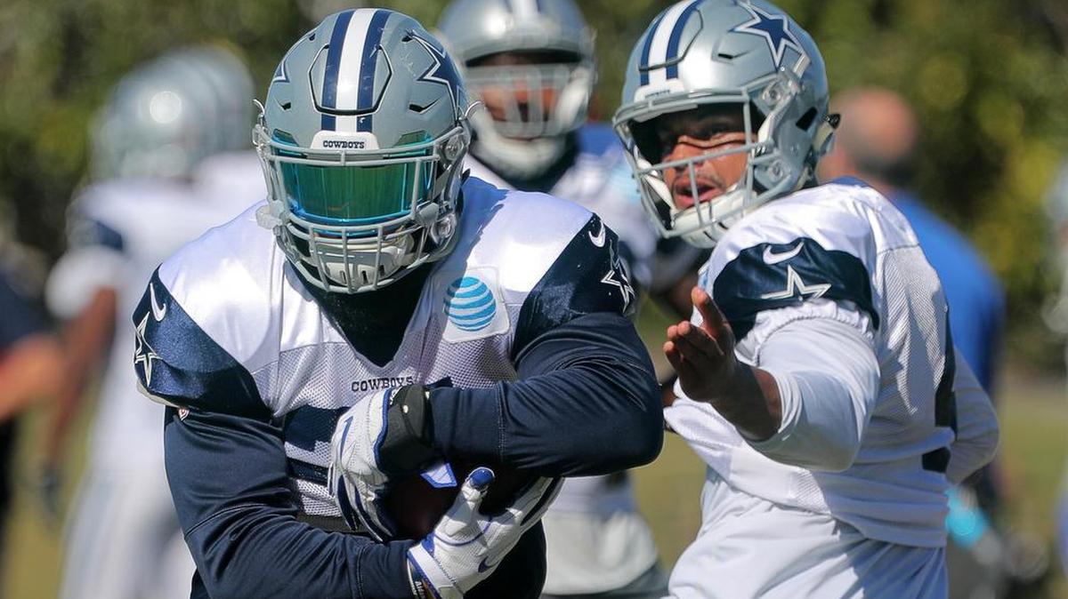 Running back Ezekiel Elliott takes a handoff from quarterback Dak Prescott during practice Wednesday at The Star in Frisco.