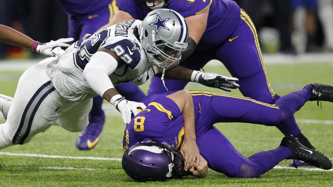 Cowboys defensive tackle Cedric Thornton, left, wraps up Vikings quarterback Sam Bradford. Dallas collected two sacks Thursday night.