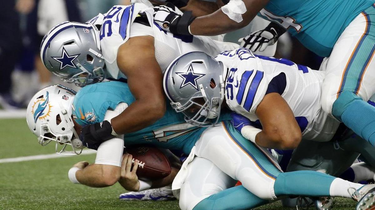 Miami Dolphins quarterback Ryan Tannehill is sacked by Dallas Cowboys defensive linemen Jack Crawford, top, and Tyrone Crawford in the first half of an NFL preseason football game, Friday, Aug. 19, 2016, in Arlington.