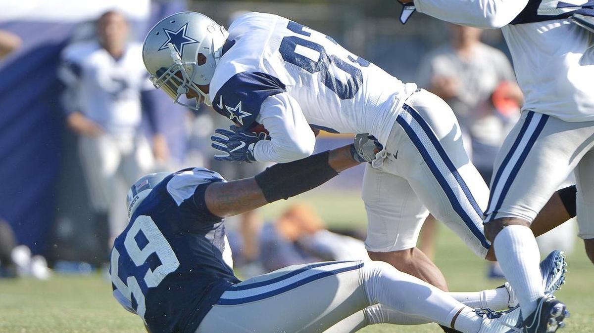 Cowboys receiver Terrance Williams runs over middle linebacker Anthony Hitchens during Wednesday’s practice in Oxnard. The Cowboys have been showing some fight during training camp.
