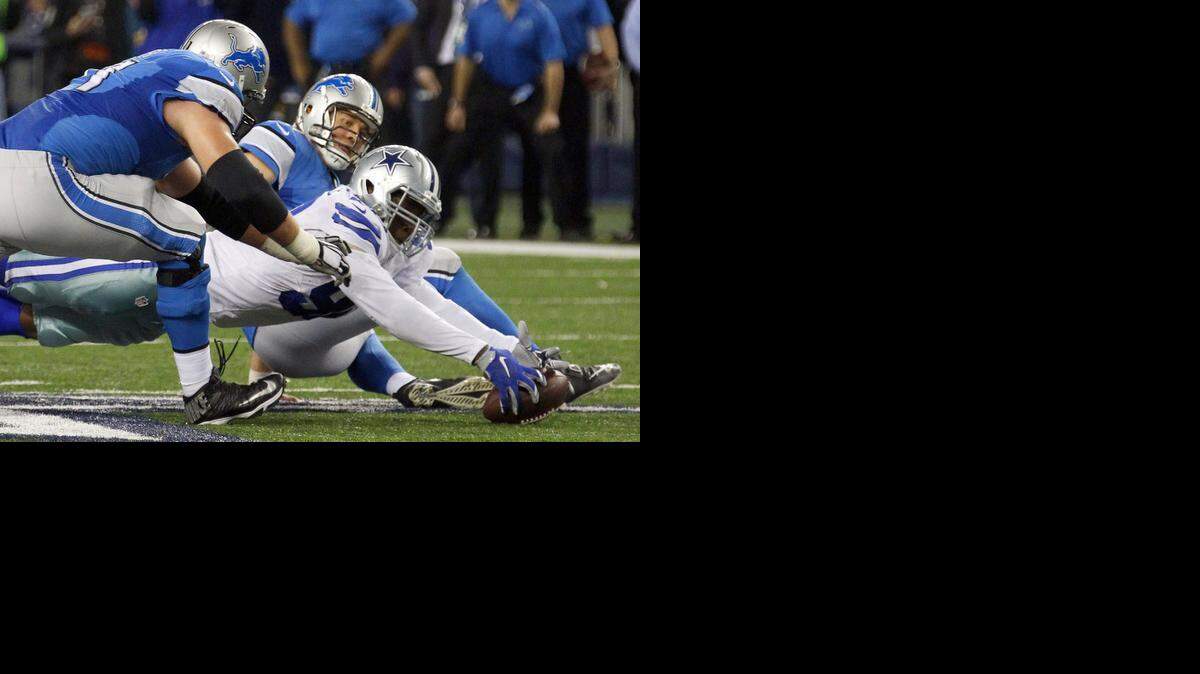 
Lions tackle Riley Reiff, left, and quarterback Matthew Stafford, center, try to recover the fumble as Cowboys defensive end Demarcus Lawrence grabs the ball at the end of the fourth quarter
