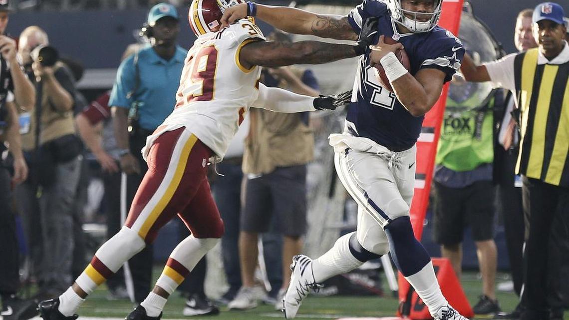 Dallas Cowboys quarterback Dak Prescott, right, tries to fend off Washington Redskins safety Donte Whitner Sr. (39) during the first half an NFL football game in Arlington on Thursday, November 24, 2016. Prescott threw for 195 yards and ran for 39, including a touchdown.