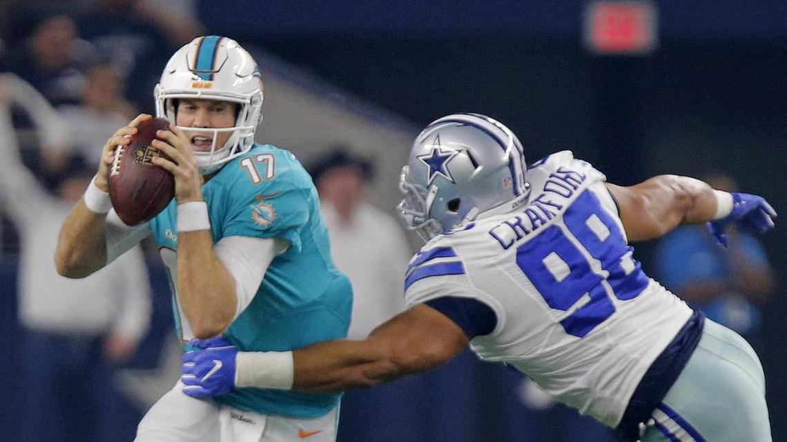 Dallas Cowboys defensive tackle Tyrone Crawford, right, sacks Miami Dolphins quarterback Ryan Tannehill (17) in the first quarter.