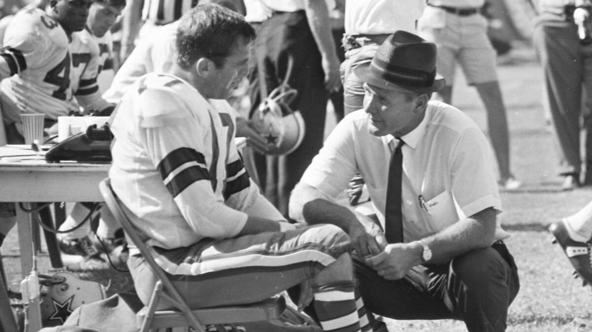 Dallas Cowboys quarterback Don Meredith and head coach Tom Landry talk on the sidelines during a 1967 NFL game.