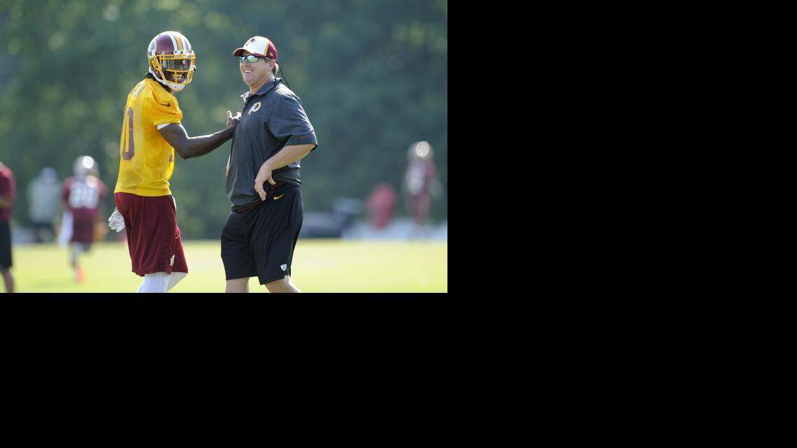 
Redskins coach Jay Gruden, right, says he only judges quarterbacks, including Robert Griffin III, on winning.
