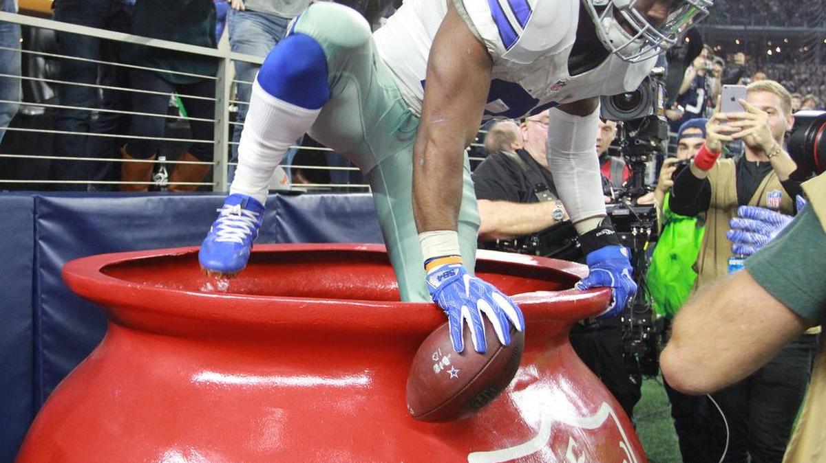 Cowboys running back Ezekiel Elliott (21) jumped into a Salvation Army kettle after a touchdown run in the second quarter, drawing a 15-yard penalty.