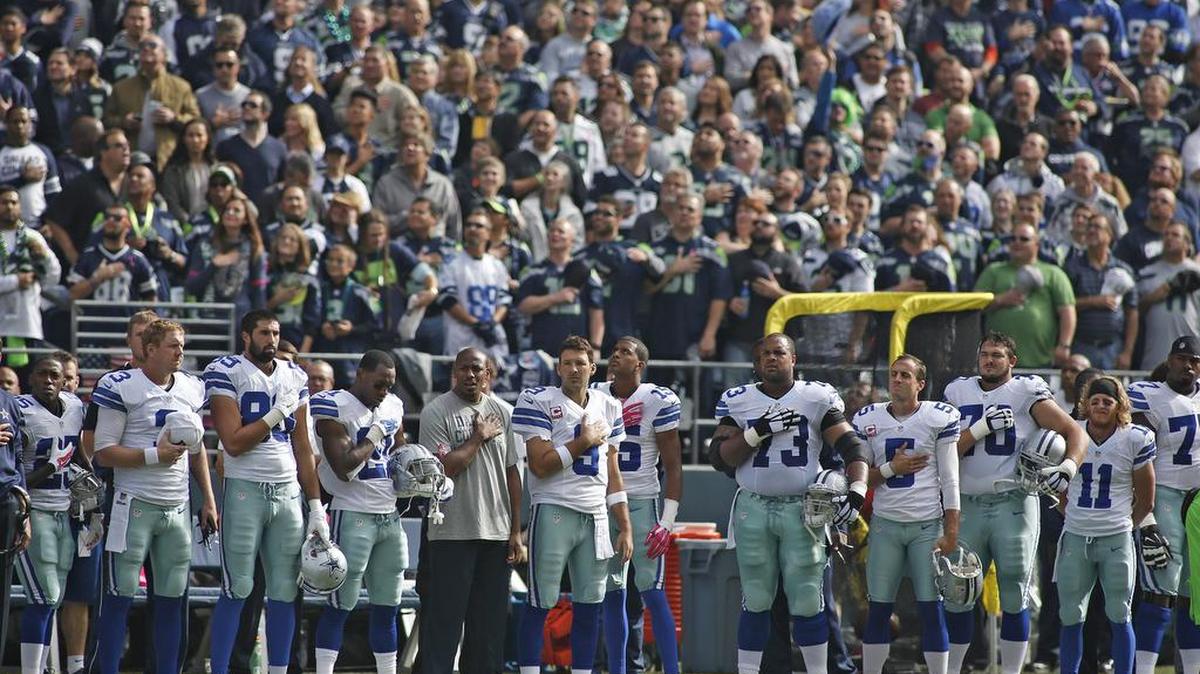 Dallas Cowboys quarterback Tony Romo (9) and teammates during the pre-game National Anthem.