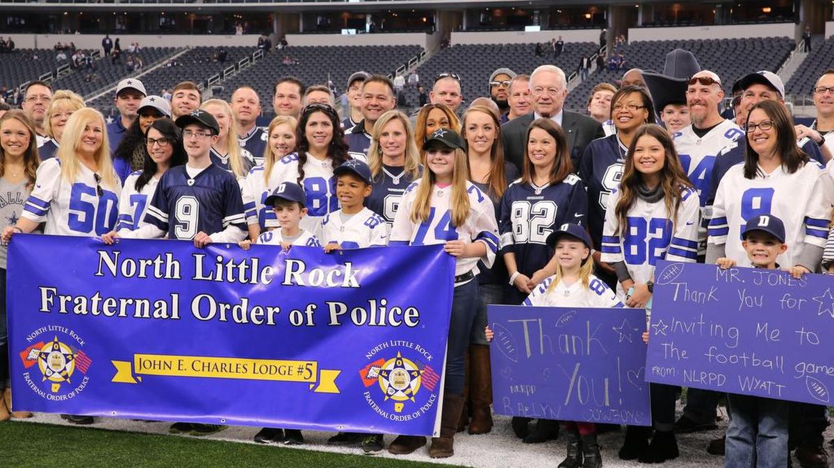 Dallas Cowboys owner Jerry Jones takes a group photo with officers of the North Little Rock Police Department and their families before the game between the Baltimore Ravens and the Cowboys at AT&T Stadium.