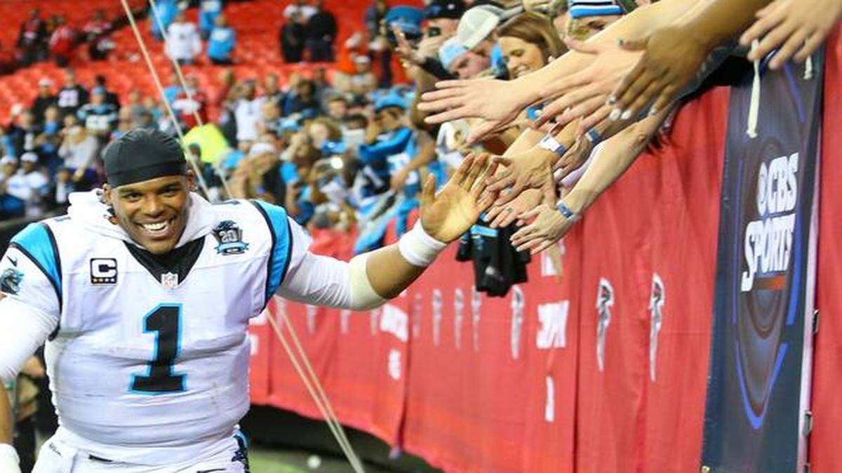 
Panthers quarterback Cam Newton high-fives fans after beating the Falcons 34-3 to win the NFC South on Sunday. 
