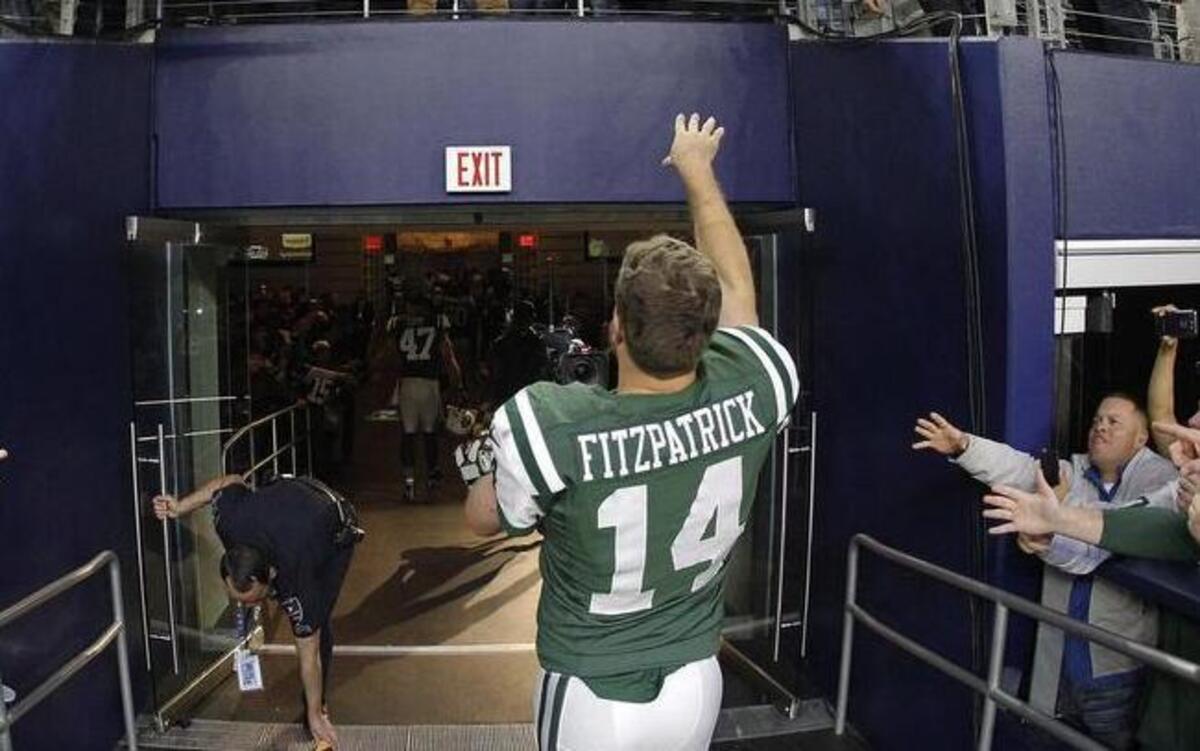 New York Jets quarterback Ryan Fitzpatrick tosses his wristband to Jets fans after the game.