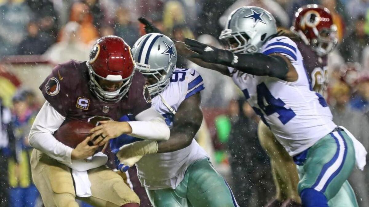 Defensive end DeMarcus Lawrence and outside linebacker Jaylon Smith wrap up Washington Redskins quarterback Kirk Cousins on Sunday, one of the Cowboys’ four sacks.