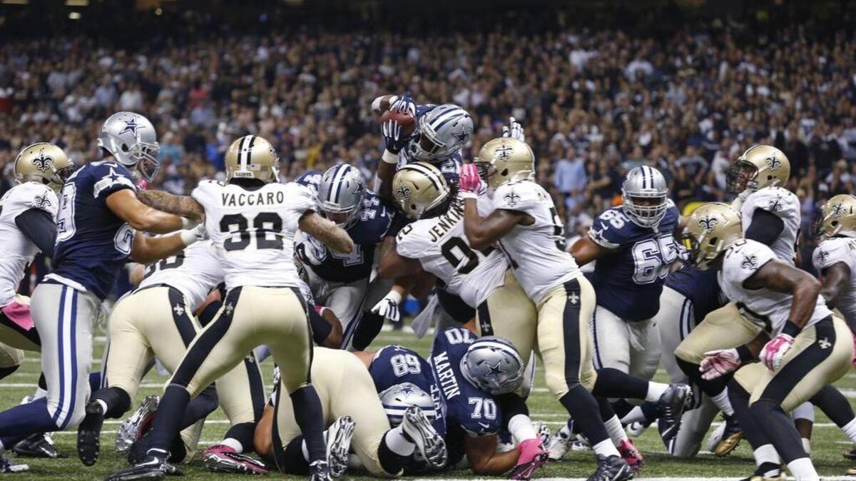 
Cowboys running back Joseph Randle (21) leaps over the pile for a touchdown in what originally was ruled a fumble.
