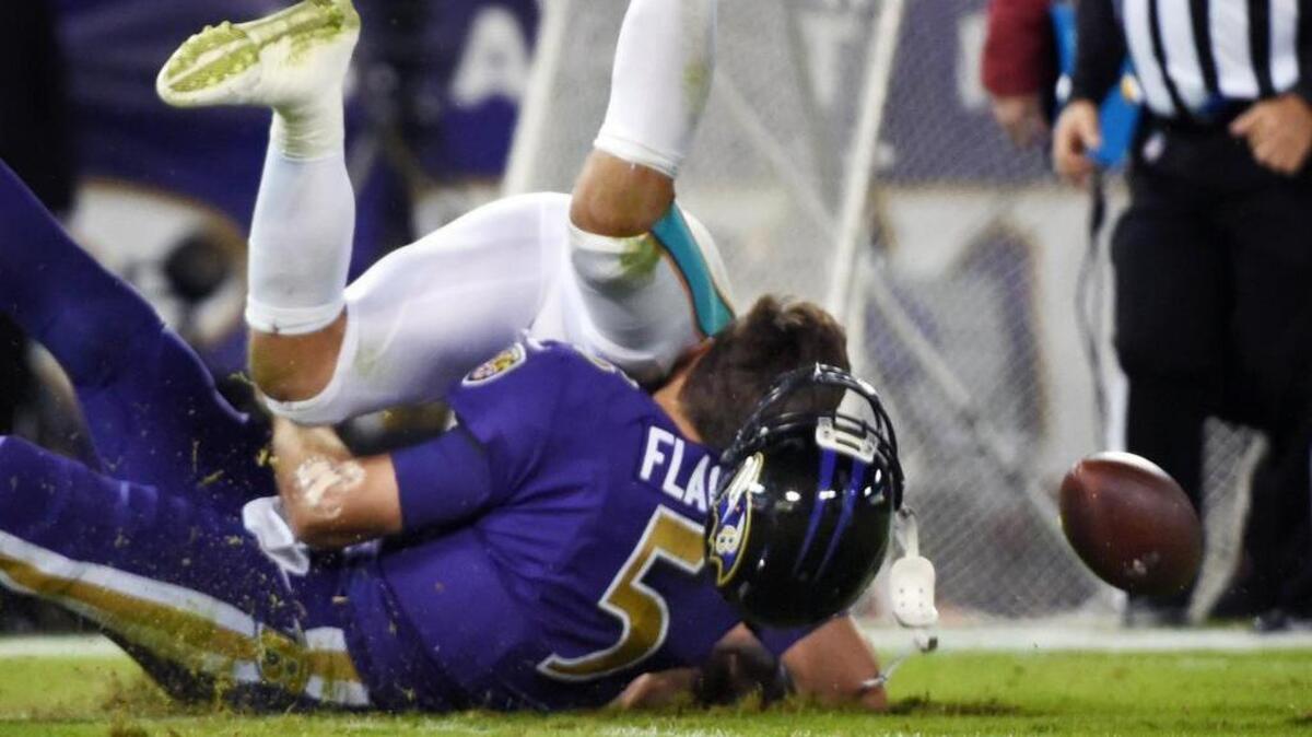 Baltimore Ravens quarterback Joe Flacco is flattened by the Miami Dolphins’ Kiko Alonso on Oct. 26. Flacco sustained a concussion on the play.