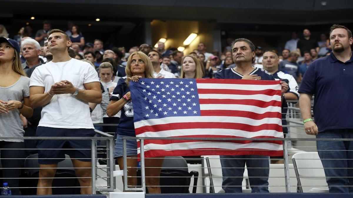 Fans hold an American flag during the national anthem before the Cowboys game against the Rams on Oct. 1 at AT&T Stadium.