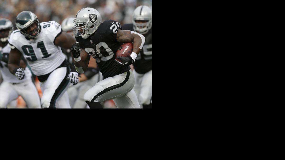 
Darren McFadden tries to run past Eagles defensive end Fletcher Cox during a 2013 game with the Oakland Raiders.
