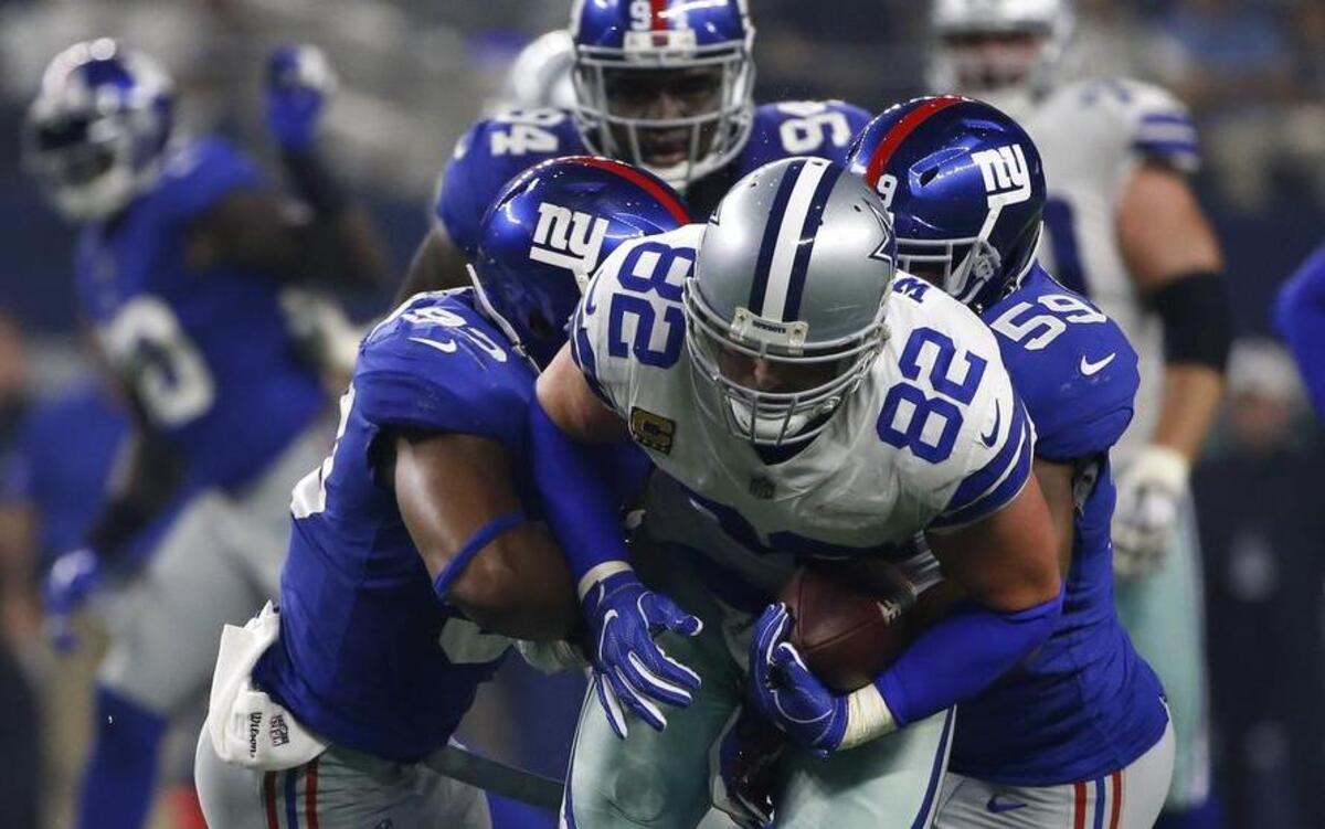 Giants linebacker B.J. Goodson, left, and linebacker Devon Kennard, right, tackle Cowboys tight end Jason Witten after Witten caught a pass breaking the Cowboys all-time receiving yards record held by Michael Irvin in the second quarter of the Cowboys’ 19-3 win over the Giants Sunday night at AT&T Stadium.