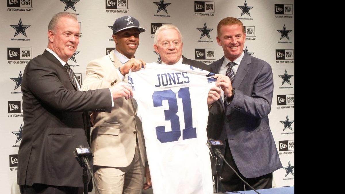 
Byron Jones holds a team jersey with Stephen Jones (left), Jerry Jones and Jason Garrett (right) on Friday. 
