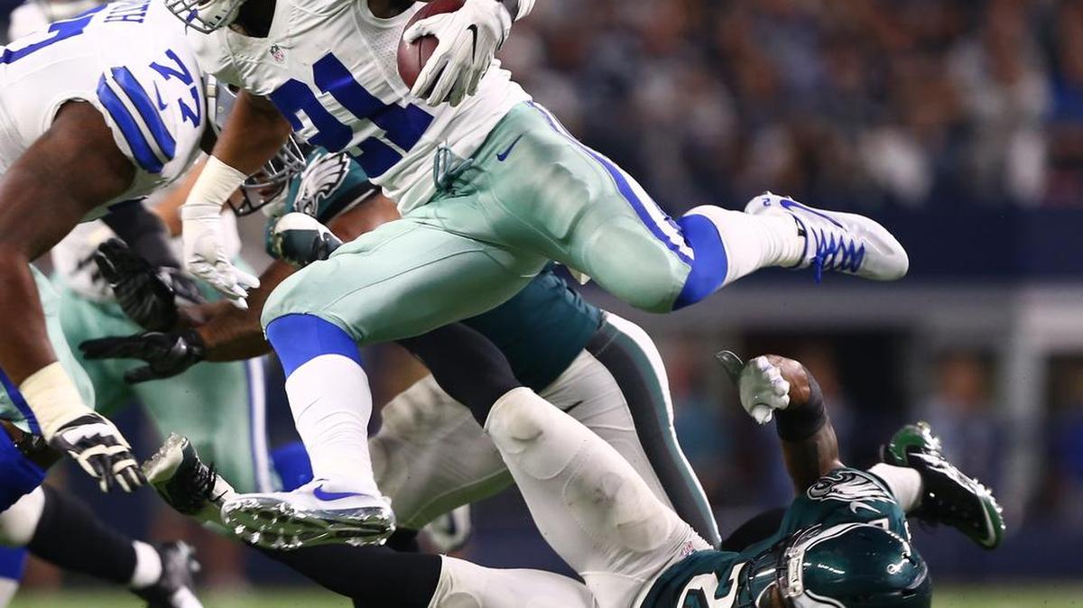 Cowboys running back Ezekiel Elliott (21) leaps over Eagles safety Rodney McLeod (23) on Sunday.