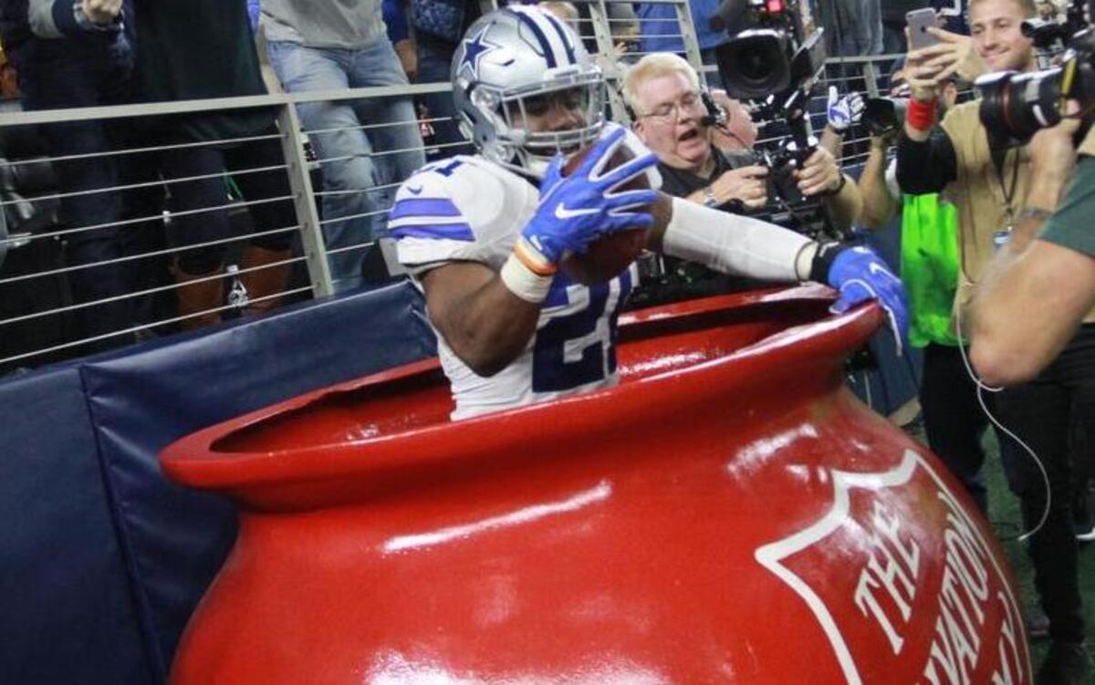 Dallas Cowboys running back Ezekiel Elliott celebrates a touchdown inside the Salvation Army red kettle.