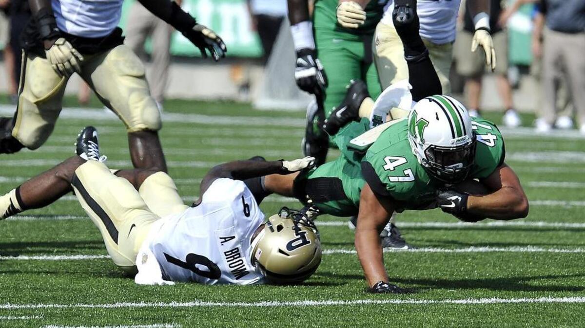 Purdue’s Anthony Brown (No. 9, left) was selected by the Cowboys.