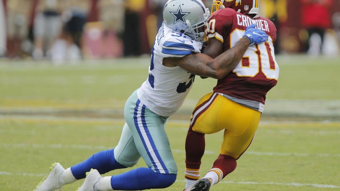 Cowboys cornerback Orlando Scandrick, left, brings down Redskins receiver Jamison Crowder on Sunday. Scandrick has played in both games this season despite hamstring strains.