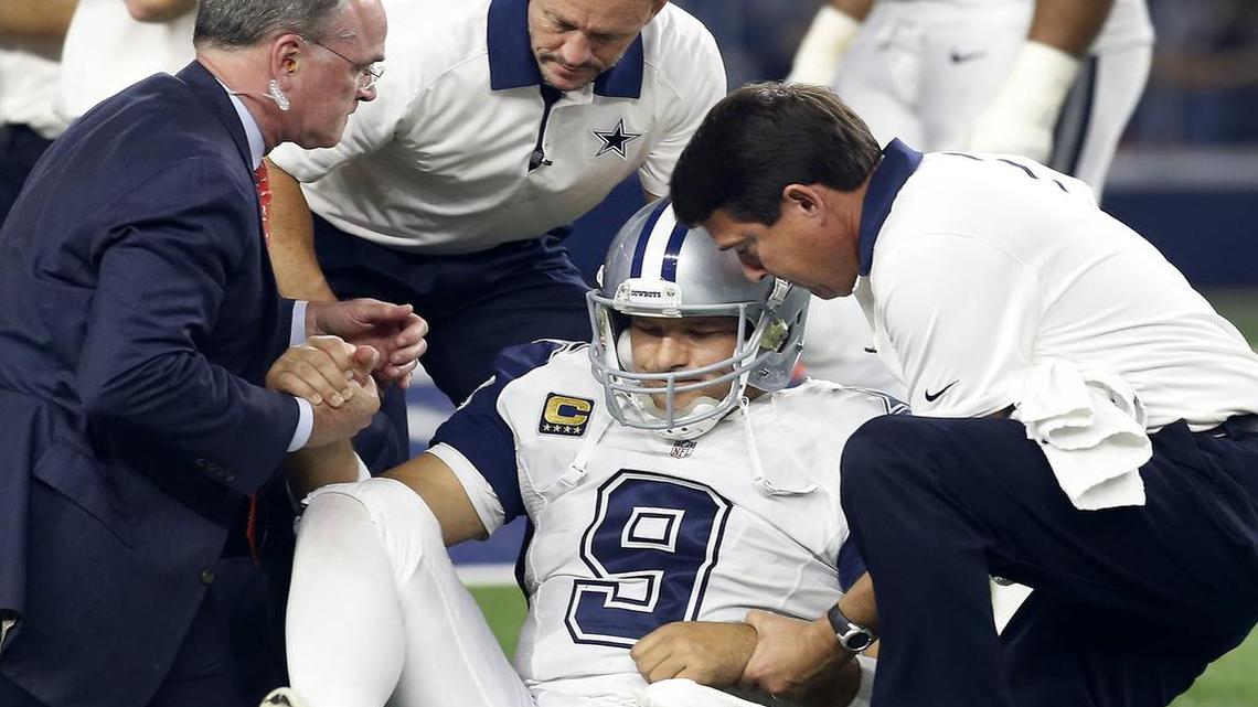 Dallas Cowboys quarterback Tony Romo is helped up by medical staff after being injured on a sack by the Carolina Panthers in the second half at AT&T Stadium in Arlington.