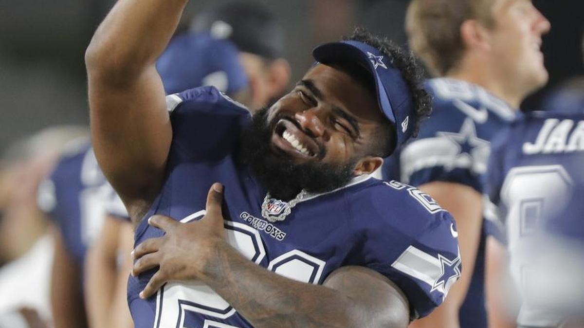 Dallas Cowboys running back Ezekiel Elliott (21) jokes around on the sideline as the Los Angeles Rams beat the Dallas Cowboys 13-10 in a preseason game Saturday night. Elliott, who has been suspended for the first six games of the season, did not play in the game.
