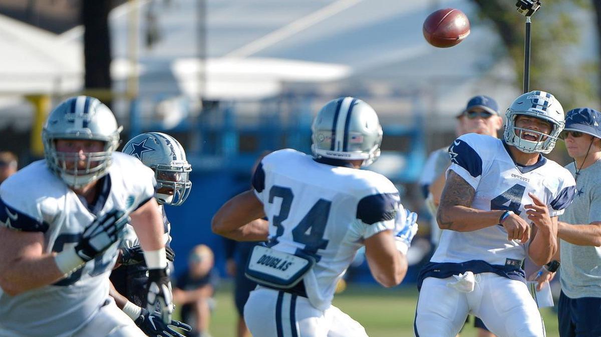 Cowboys quarterback Dak Prescott (4) floats one to running back Darius Jackson (34) during Wednesday’s practice.