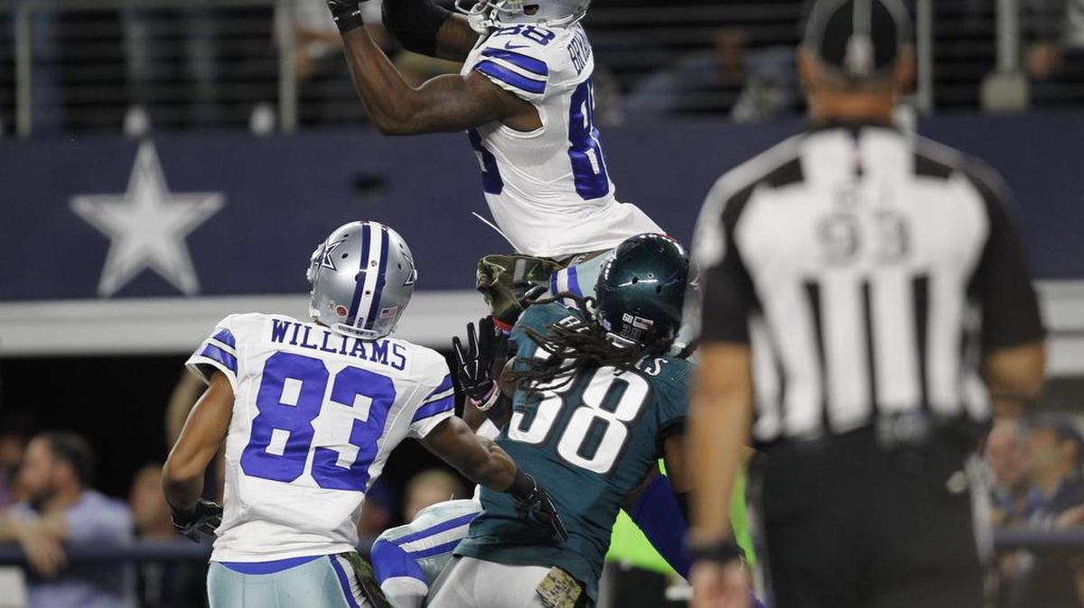 Cowboys receiver Dez Bryant (88) leaps over a crowd to pull in an 18-yard pass that Matt Cassel threw up for grabs.