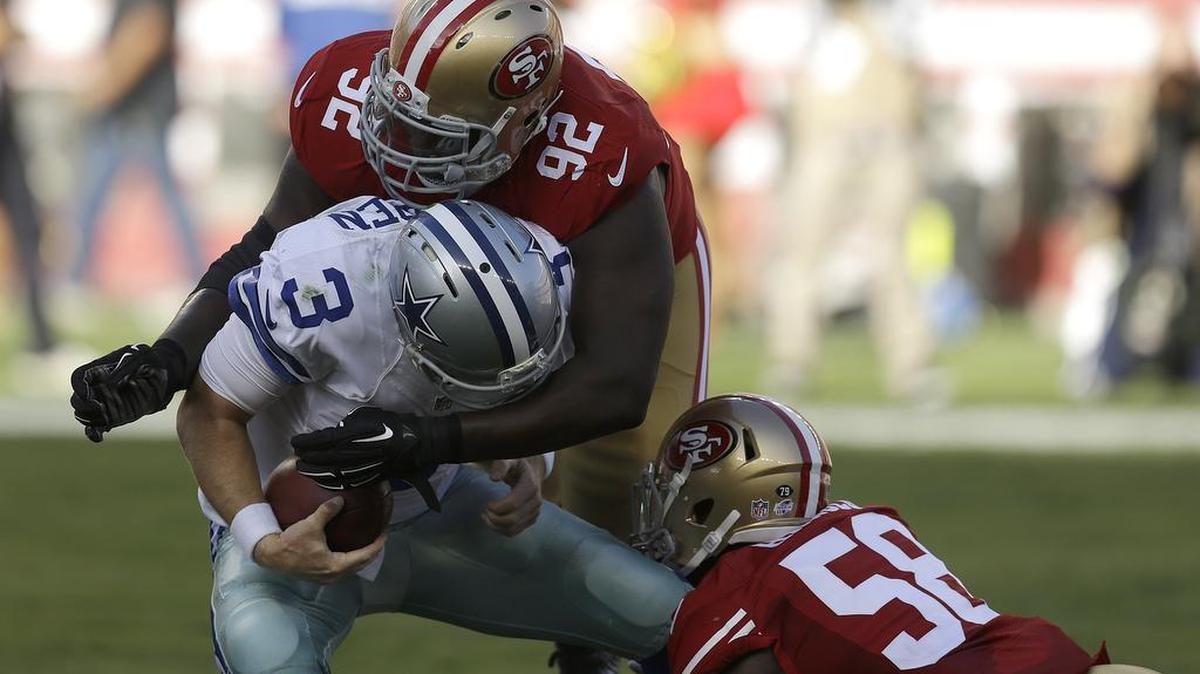 
Dallas Cowboys quarterback Brandon Weeden (3) takes a shot in the back of head from Quinton Dial (92) while Eli Harold (58) wraps up Weeden’s leg. 
