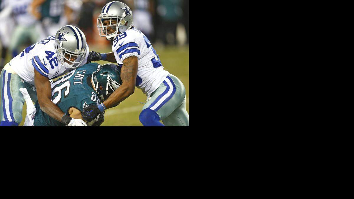 
Dallas Cowboys strong safety Barry Church (42) and cornerback Brandon Carr (39) take down Philadelphia Eagles tight end Zach Ertz (86) in the Cowboys’ victory Sunday night. 
