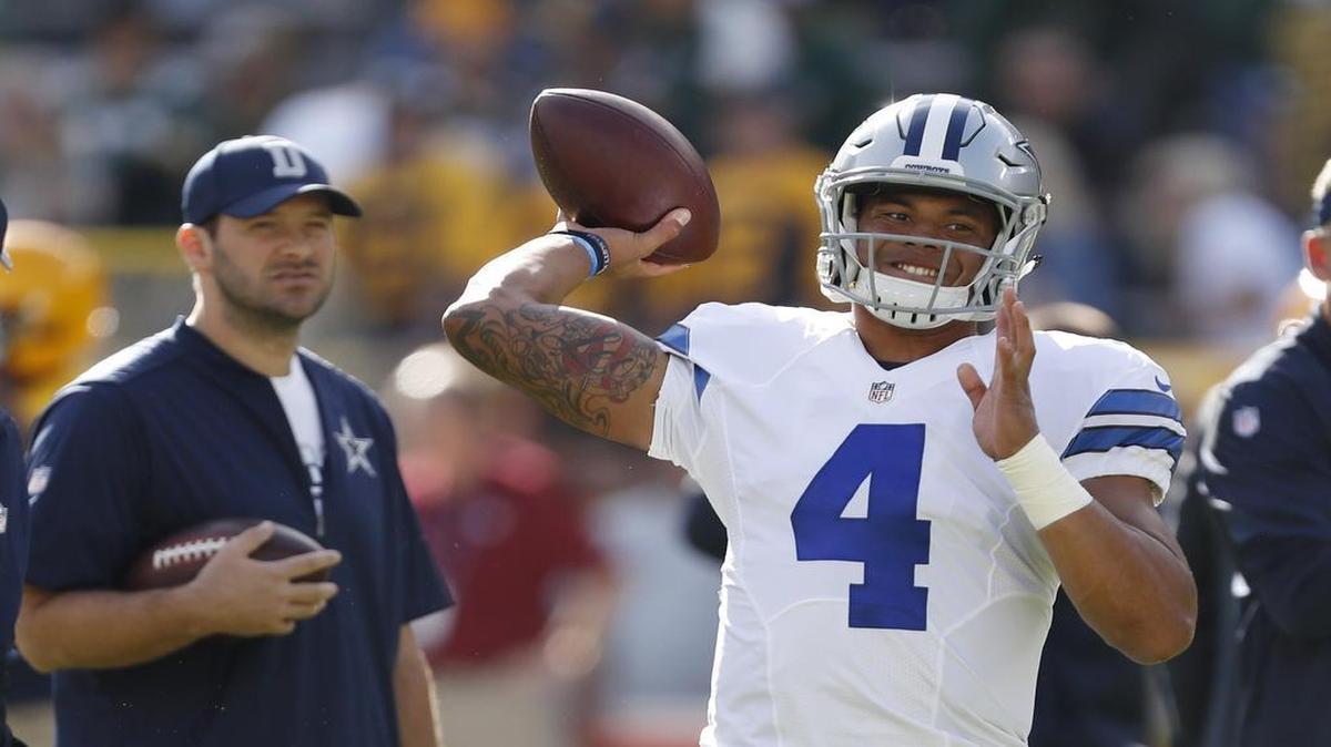 Dallas Cowboys quarterback Dak Prescott, right, warms up Sunday before playing the Green Bay Packers as Tony Romo, left, watches. Romo has missed the first six games of the season.
