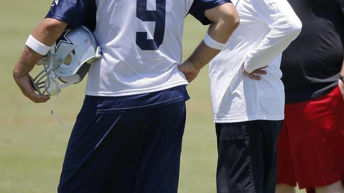 Dallas Cowboys quarterback Tony Romo (9) talks with SMU head basketball coach Larry Brown, right, during Wednesday’s OTA.