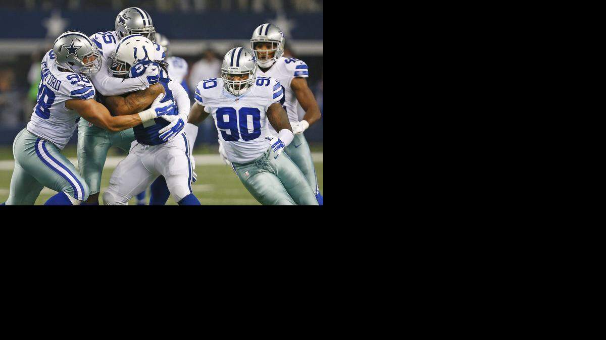 
Dallas Cowboys defensive tackle Tyrone Crawford (98) and middle linebacker Rolando McClain (55) combine efforts to stop Indianapolis Colts running back Trent Richardson in the second half. The Dallas Cowboys defeated the Indianapolis Colts 42-7 to win the NFC East on Sunday, Dec. 21, 2014 in Arlington, Texas.
