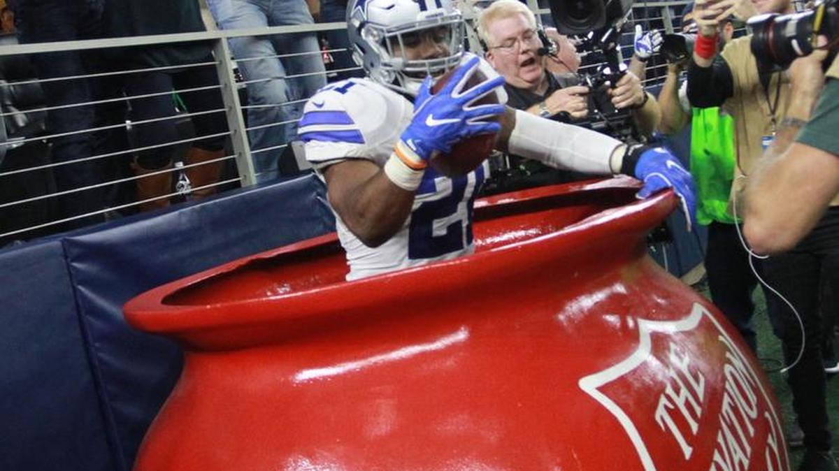 Cowboys running back Ezekiel Elliott (21) jumps in the Salvation Army red kettle after he scored a second-quarter touchdown.