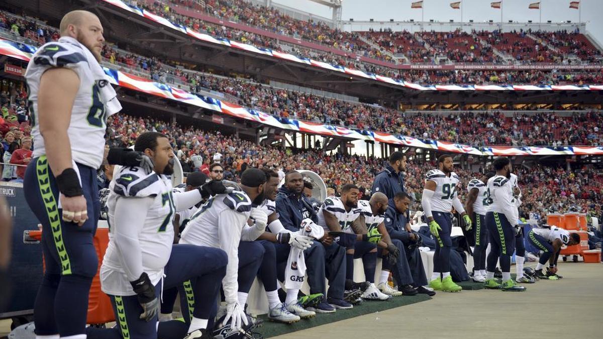Seahawks players sit and kneel during the playing of the national anthem before a game against the 49ers, in Santa Clara, Calif., on Nov. 26.